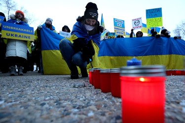 Edmontonians light candles as they mark the one-year anniversary of Russia's full-scale invasion of Ukraine with a vigil outside the Alberta Legislature in Edmonton, Friday Feb. 24, 2023.