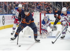 Ryan McLeod (71)of the Edmonton Oilers, tries to make a play beside the net of goalie Igor Shesterkin (31) of the New York Rangers at Rogers Place in Edmonton on February 17, 2023.   Photo by Shaughn Butts-Postmedia