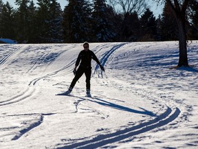 Seorang pemain ski memanfaatkan cuaca hangat dan segarnya salju di Taman Capilano pada Rabu, 8 Februari 2023, di Edmonton.