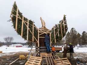 Kapten pemadam kebakaran Phoenix Jeremy Teeuwsen mengisi tubuh burung phoenix dengan pohon Natal yang akan dibakar pada Sabtu, 18 Februari 2023 di Taman Hawrelak di Edmonton. Sejak 2009, Silver Skate Festival telah menyelenggarakan instalasi patung api. Tontonan cahaya yang memukau ini berfungsi sebagai akhir cerita Silver Skate Folk Trail. Greg Southam-Postmedia