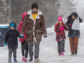 A family of five walk towards the Canada - USA border at Lacolle on Thursday Feb. 23, 2023 in hopes of becoming Canadian refugees.