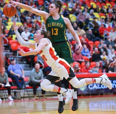 University of Alberta Pandas forward Claire Signatovich attempts to block a shot by University of Calgary Dinos guard Mackenzie Trpcic during Canada West Women's basketball final action at the University of Calgary on Saturday, March 4, 2023. The U of A won the game 76-65.