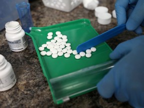 FILE PHOTO: A pharmacist counts prescription drugs at the at the CentreTown Pharmacy in Ottawa, Ontario, Canada, June 12, 2019. REUTERS/Chris Wattie/File Photo ORG XMIT: FW1