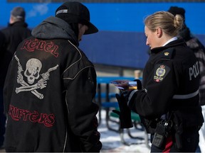 Insp. Angela Kemp gives a man a Boyle Street housing card after they started chatting along 101 Street near 105 Avenue in Edmonton on March 1, 2023.