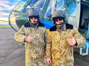 Pilot helikopter Ukraina memakai helm penerbangan yang disumbangkan di Alberta dan dibawa oleh petugas perdamaian Edmonton Daniel Laskavenko.