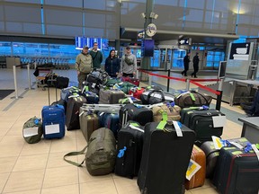 Edmonton peace officer Daniel Laskavenko, Shannon Boddez, a nurse at Royal Alexandra Hospital, business owner Dave Bryenton and Ukrainian student Oleh Bishko with some of the 47 bags of Canadian kit destined to be donated in Ukraine, at the Edmonton International Airport.