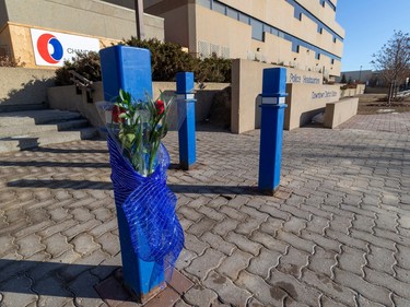 Flowers are taped to a post outside the downtown police station after two officers were killed Thursday morning while responding to a call in the city's northwest. The officers were identified as Const. Travis Jordan, 35 and Const. Brett Ryan, 30. Jordan was an 8.5-year veteran of the Edmonton Police Service, while Ryan was with the EPS for 5.5 years. Taken on Thursday, March 16, 2023 in Edmonton.    Greg Southam-Postmedia
