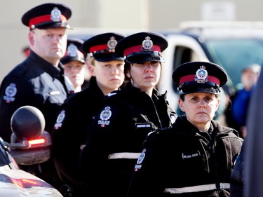 Edmonton Police Service members gather at the Serenity Funeral Home as a procession arrives with the bodies of Const. Travis Jordan and Const. Brett Ryan, in Edmonton Tuesday March 21, 2023.