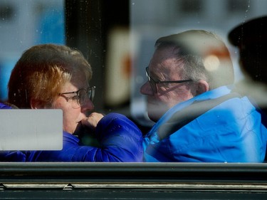 The family of Const. Brett Ryan look out from a transit bus as Edmontonians line the street around the Serenity Funeral Home, in Edmonton Tuesday March 21, 2023. A procession moved the bodies of Const. Travis Jordan and Const. Brett Ryan from the Medical Examiner's office to the funeral home Tuesday.