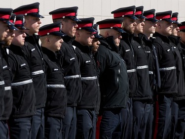 Edmonton Police Service recruits line the street around the Serenity Funeral Home as a procession arrives with the bodies of Const. Travis Jordan and Const. Brett Ryan, in Edmonton Tuesday March 21, 2023.