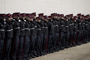 Edmonton Police Service recruits line the street around the Serenity Funeral Home as a procession arrives with the bodies of Const. Travis Jordan and Const. Brett Ryan, in Edmonton Tuesday March 21, 2023.
