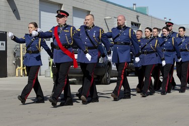 An Honour Guard marches into the Serenity Funeral Home as a procession arrives with the bodies of Const. Travis Jordan and Const. Brett Ryan, in Edmonton Tuesday March 21, 2023.