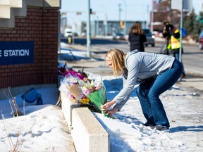 Brenda Baron brings flowers to the West Division station of the  Edmonton Police Service on Friday, March 17, 2023, as she pays tribute to Const. Travis Jordan and Const. Brett Ryan, who were killed in the line of duty on Thursday. Baron's son-in-law is a police officer at West Division.