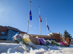 Flags are at half-mast and flowers are laid along the sidewalk in from of West Division Police Station, to honour Const. Travis Jordan and Const. Brett Ryan, who were killed on Thursday morning while on a call for a domestic dispute. Taken on Friday, March 17, 2023, in Edmonton.