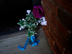 Flowers lie outside the front door of the Baywood Apartment complex, 11445 132 St., on Monday March 20, 2023, following the shooting deaths of Const. Travis Jordan and Const. Brett Ryan last Thursday.