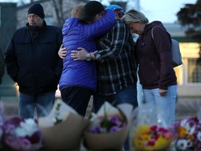 The family of Const. Brett Ryan comforts each other as they take part in a vigil outside the West Division EPS Station, in Edmonton Friday, March 17, 2023. Const. Travis Jordan and Const. Brett Ryan were both killed in the line of duty March 16, 2023. Both officers worked out of the West Division Station.