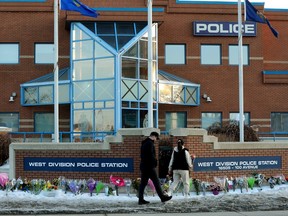 A couple leaves flowers outside the West Division EPS Station, in Edmonton Friday, March 17, 2023. Const. Travis Jordan and Const. Brett Ryan were both killed in the line of duty March 16, 2023. Both officers worked out of the West Division Station.