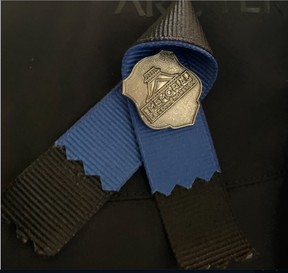 Pita peringatan garis biru tipis dan pita di atas jantung seorang petugas polisi pada Kamis, 16 Maret 2023, di markas pusat kota Edmonton Police Service.