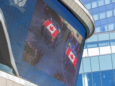 The big screen television in the Ice District shows the flags being folded from the coffins of EPS constables Brett Ryan and Travis Jordan, during the regimental funeral on Monday, March 27, 2023 in Edmonton.