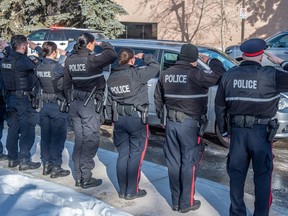 Police officers honoured their fallen colleagues as they were transported to the medical examiners office by an escort of police, fire and EMS on March 16, 2023 in Edmonton. Two EPS members were killed in the line of duty after responding to a domestic call earlier in the day.