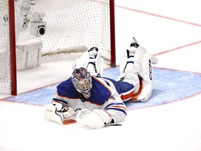 Edmonton Oilers goalie Stuart Skinner lies on the ice after giving up a goal to Los Angeles Kings' Phillip Danault.
