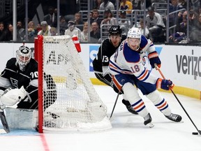 Zach Hyman of the Edmonton Oilers looks to pass as he is watched by Joonas Korpisalo and Gabriel Vilardi of the Los Angeles Kings during the third period during a 5-4 Oilers overtime win in Game Four of the First Round of the 2023 Stanley Cup Playoffs at Crypto.com Arena on April 23, 2023 in Los Angeles, California.