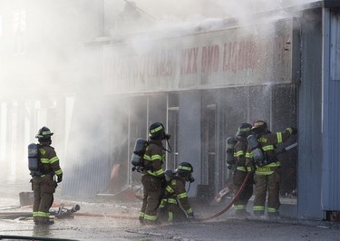 Firefighter work at a fire at Times Square XXX, 15539 Stony Plain Rd., in Edmonton Friday, April 14, 2023.