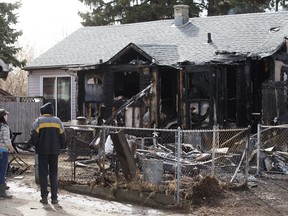 Neighbours look at the damage following an early morning house fire near 72 Street and 129 Avenue on Edmonton on Monday, April 24, 2023. Police are investigating the fire as an arson.