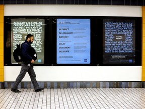 An ETS driver walks past a new poster campaign in the Corona LRT station, Wednesday, April 5, 2023. The City of Edmonton has launched a bystander awareness campaign to help reduce gender-based violence and harassment in transit spaces.