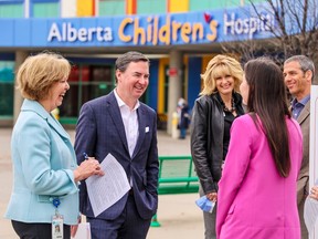 Health Minister Jason Copping chats with guests including Margaret Fullerton, senior operating officer, Alberta Children's Hospital, left, and past patient Maddison Tory, in pink, before a news conference at the Alberta Children's Hospital in Calgary on Monday, April 24, 2023. The province announced new funding for pediatric beds and dedicated staffing at both children's hospitals in Alberta.