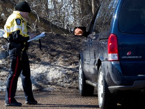 A motorist reacts to getting a speeding ticket as members of the Edmonton Police Service take part in speed enforcement along Scona Road at 94 Avenue in Edmonton on March 13, 2014.