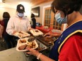 Volunteer Edna Adefuin (right) serves dinner during the Millbourne Laundromat 29th Annual Thanksgiving Luncheon, at the Leefield Community Hall, 7910 36 Avenue, Monday Oct. 10, 2022. Organizers say they gave out 600 meals to the community and sent another 200 meals to students at the University of Alberta. The event was sponsored by the Rotary Club of Edmonton Southeast, the Thrive Outreach Foundation, Leefield Community League and the Millbourne Laundromat.