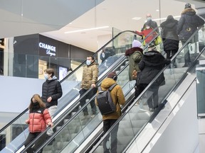 People are shown in a shopping mall in Montreal, Saturday, January 15, 2022. RBC says Canadians are continuing to spend on holidays and non-essential services, but are cutting back on restaurants and goods.