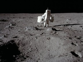 Lunar module pilot Buzz Aldrin carries equipment to the deployment area on the surface of the moon at Tranquility Base on July 20, 1969. China plans to start building a lunar base in about five years, report says.