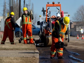 A City of Edmonton crew fills potholes along 143 Street near 114 Avenue in Edmonton on Wednesday, April 12, 2023.