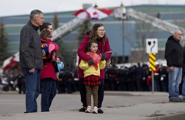 Members of the public hold red paper hearts as they watch the regimental funeral procession for Const. Harvinder Singh Dhami in Sherwood Park, Alta., Thursday April 20, 2023. Photo by David Bloom