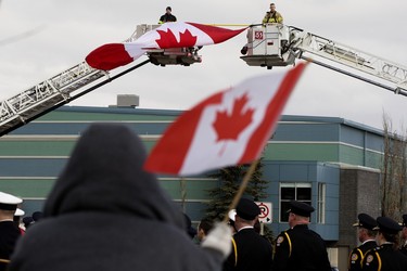 Firefighters and members of the public watch the regimental funeral procession for Const. Harvinder Singh Dhami in Sherwood Park, Alta., Thursday April 20, 2023. Photo by David Bloom
