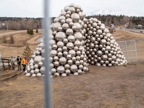 Workers surround the Talus Dome with a fence  on Monday, April 10, 2023, after a man who climbed onto it had to be rescued by firefighters when he trapped himself inside it over the Easter weekend, and is facing a criminal charge for the stunt.