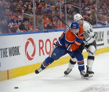 Kailer Yamamoto (56) of the Edmonton Oilers, is checked by Mikey Anderson of the Los Angeles Kings at Rogers Place in Edmonton on April 19, 2023.