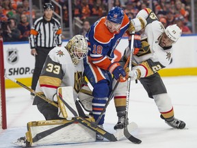 Zach Hyman of the Edmonton Oilers, is sandwiched between Adin Hill and Alec Martinez of the Las Vegas Golden Knights.