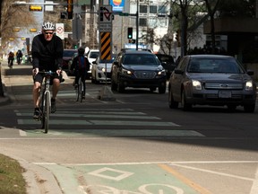Cyclists travel along divided bike lane on 99 Avenue near 107 Street in Edmonton, on Monday, May 6, 2019. Photo by Ian Kucerak/Postmedia