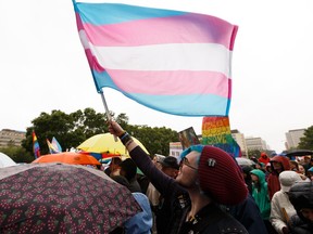 A demonstrator flies a transgender pride flag during the Rally to Save Gay-Straight Alliances at the Alberta Legislature in Edmonton, on Wednesday, June 19, 2019. The rally was held to voice opposition to Bill 8, the Education Amendment Act, which repeals rules around protecting the privacy of students involved in gay straight alliances. Photo by Ian Kucerak/Postmedia