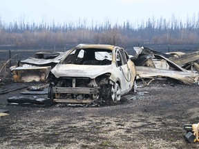 Damaged vehicles sit near the property of Adam Norris in Drayton Valley on Monday, May 8, 2023. Alberta struggled on Monday to control wildfires that have forced thousands to flee, halted oil production and threatened to raze towns.
