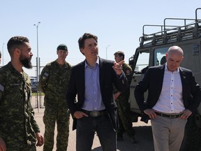 Canada's Prime Minister Justin Trudeau and Minister of Tourism Randy Boissonnault speak with Canadian Forces personnel at CFB Edmonton who are assisting in wildfire relief efforts in Sturgeon County, Alberta, Canada May 15, 2023.