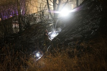 Firefighters work at the scene of a large brush fire below the Courtyard by Marriott Edmonton, Thursday, April 27, 2023.