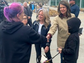 Alberta NDP Leader Rachel Notley, left, and Alberta UCP Leader Danielle Smith meet with evacuees from Alberta wildfires at the Edmonton Expo Centre on Sunday, May 7, 2023.