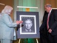 The official stamp is unveiled by Donald Booth, right, Canadian Secretary to the King, right, and Jo-Anne Polak, Senior Vice-President, Corporate and Employee Communication at Canada Post during coronation celebrations in honour of King Charles III in Ottawa, on Saturday, May 6, 2023.