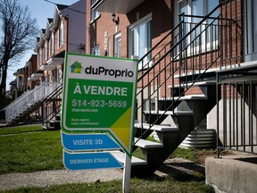 A for sale sign in front of a house in Montreal.