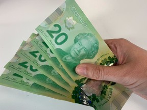Canadian $20 bills are pictured in Toronto on September 9, 2022. Countries around the world whose currencies pay tribute to the late Queen Elizabeth II now have a new monarch -- and a decision to make about whether the King has a place on their money. THE CANADIAN PRESS/Staff