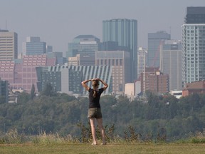 A pedestrian looks out from Forest Heights Park at the smokey haze hanging over downtown Edmonton, Monday, 22, 2022. Edmonton remains under a special air quality statement, issued by Environment Canada on Monday May 16, 2023 as smoke from ongoing wildfires has been swept into the area by winds from the north.